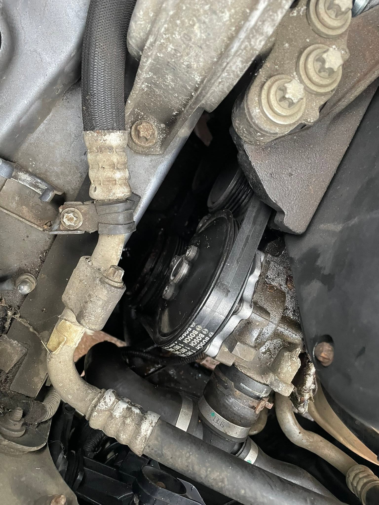 Close-up of an engine bay, pulley and pipework